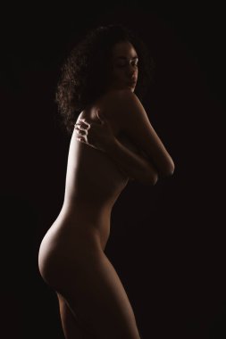 Siyah arka planda poz veren güzel çıplak kadın.