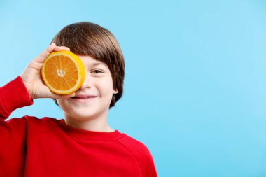 Açık mavi arka planda taze kesilmiş turuncu çocuk. Metin için boşluk