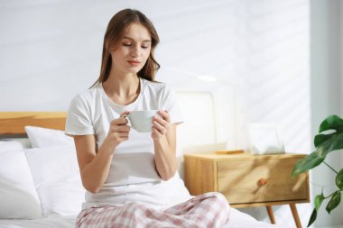 Evde yatağında bir fincan aromatik kahveyle güzel bir kadın. Metin için boşluk