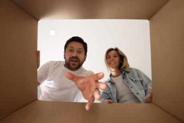 Heyecanlı çift içerideki karton kutuya bakıyor, içeriden bakıyorlar.