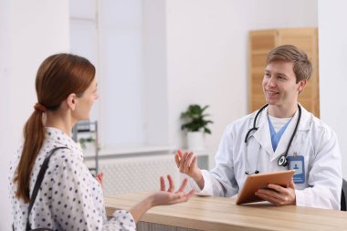 Klinikteki resepsiyonda hastaya yardım eden tıbbi asistan