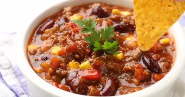 Beyaz masada nefis kırmızı biber yiyen bir kadın, yakın plan.