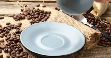 Kadın, ahşap masaya aromatik kahve koyuyor, yakın plan.