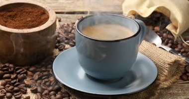 Ahşap masada, fincanda aromatik kahve içen kadın, yakın plan.