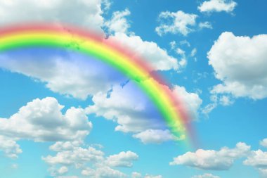 Bright colorful rainbow and clouds in blue sky