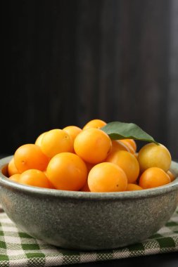 Olgun sarı kiraz erikleri ve siyah ahşap masa üzerinde yaprak. Metin için boşluk