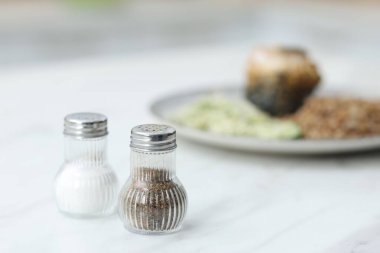 Beyaz mermer masada baharatlı tuzluklar ve biberlikler, yakın plan. Metin için boşluk