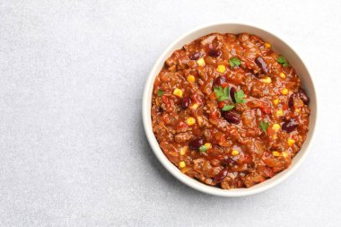 Açık gri masada kasede nefis kırmızı biberli makarna, üst manzara. Metin için boşluk