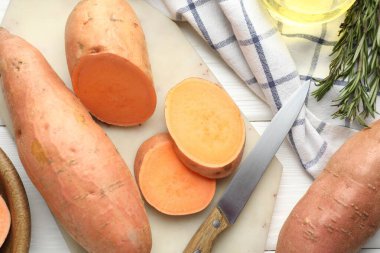 Çiğ patates, bıçak ve biberiye beyaz ahşap masa, düz yatıyordu.