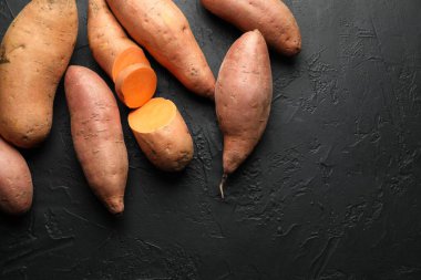 Siyah desenli masada çiğ patates, düz uzanmış. Metin için boşluk