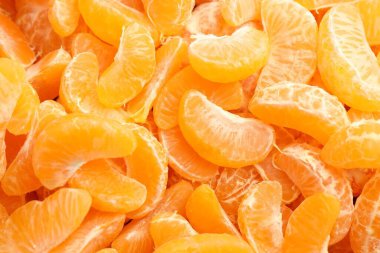 Arka plan olarak birçok olgun soyulmuş mandalina, üst görünüm