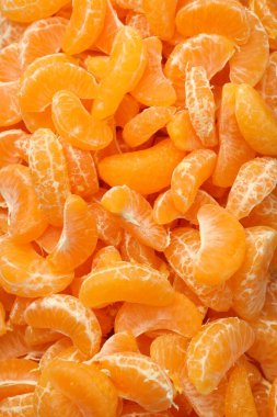 Arka plan olarak birçok olgun soyulmuş mandalina, üst görünüm