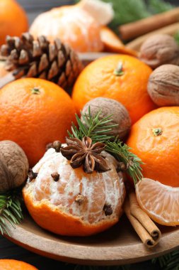 Olgun mandalinalar, baharatlar, cevizler, köknar ağacı dalları ve masa üzerinde koni, yakın çekim