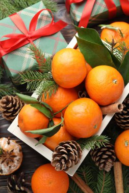 Olgun mandalinalar, baharatlar, hediye, köknar ağacı dalları ve koniler masada, düz yatıyordu.