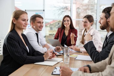 İş adamlarından oluşan bir ekip ofiste birlikte çalışıyor.