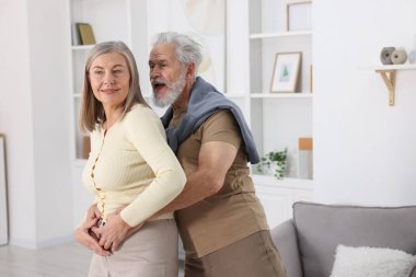 Güzel yaşlı çift evde dans ediyor.