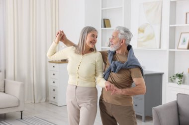 Güzel yaşlı çift evde dans ediyor.