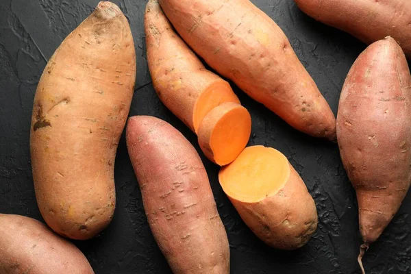 Siyah desenli masada çiğ patates, düz uzanmış.