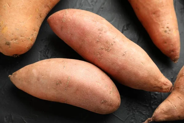 Siyah desenli masada çiğ patates, düz uzanmış.