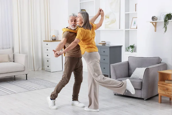 Güzel yaşlı çift evde dans ediyor.