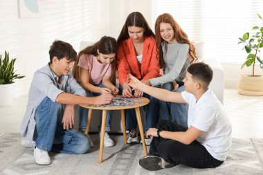 Evde bulmaca çözen bir grup genç.