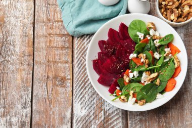 Pancar, ıspanak, peynir, ceviz ve havuç ile ahşap masada nefis bir salata. Metin için boşluk