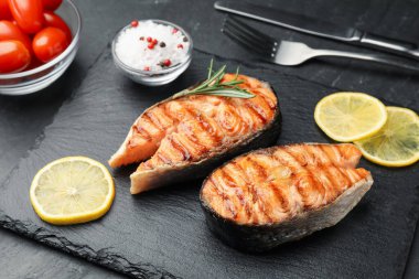 Siyah masada limonlu ızgara somon bifteği, yakın plan.