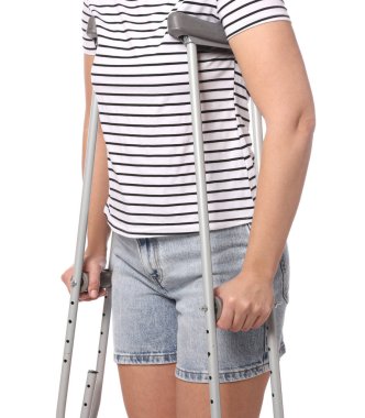 Beyaz arka planda koltuk değnekli kadın, yakın plan.