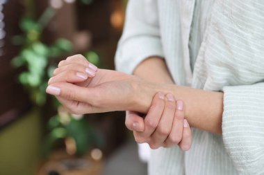 Kadın nabzını evde kontrol ediyor, yakın plan.