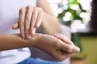 Kadın nabzını evde kontrol ediyor, yakın plan.