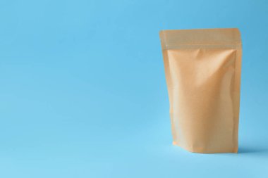 Açık mavi arka planda bir Kraft stand-up kesesi. Metin için boşluk