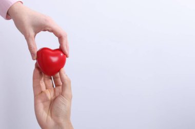 Açık gri arka planda kırmızı kalpli insanlar, yakın plan. Metin için boşluk