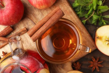 Cam fincanda aromatik meyve çayı, çaydanlık, elma, nane ve baharatlar ahşap masada, düz uzanmış