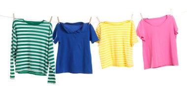 Çamaşır ipini beyaz arka planda tutarken farklı giysiler kuruyor