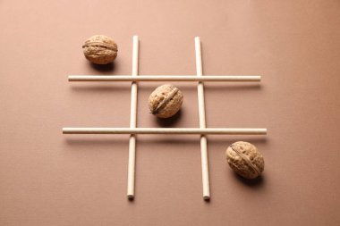 Bej arka planda cevizlerle yapılan tik tak parmak oyunu