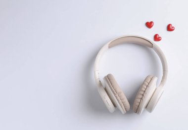 Kulaklıklar ve kalp figürleri beyaz arka planda, düz yerde. Metin için boşluk