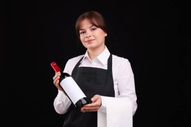 Siyah arka planda kırmızı şarap şişesi olan profesyonel şarap garsonu.