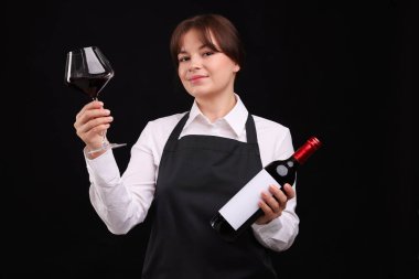 Siyah arka planda kırmızı şarap ve şişe olan profesyonel şarap garsonu.