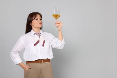 Açık gri arka planda beyaz şarap kadehi olan profesyonel şarap garsonu.