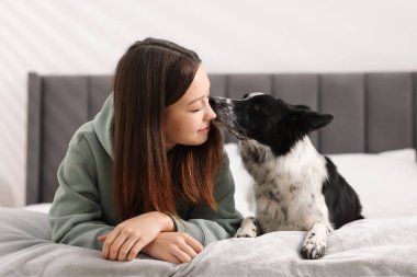 Evde yatağında Collie köpeği olan bir kadın.