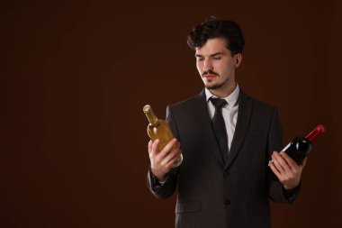 Kahverengi arka planda şarap şişeleri olan profesyonel şarap garsonu. Metin için boşluk