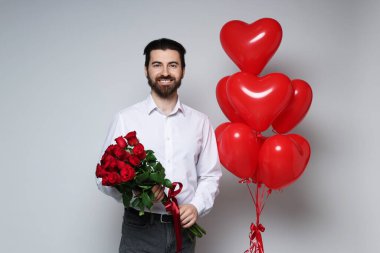 Sevgililer Günü. Buketi ve kalp şeklinde balonları olan bir adam.