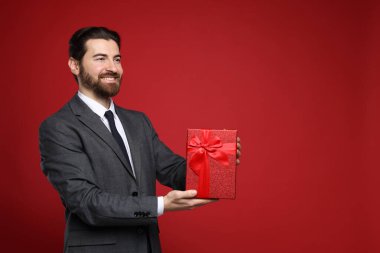 Sevgililer Günü. Kırmızı arka planda yeteneği olan yakışıklı bir adam. Metin için boşluk