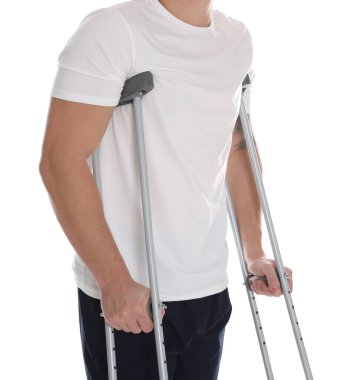 Beyaz arka planda koltuk değnekli adam, yakın plan