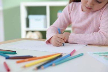 Masada pastel boyayla resim çizen sevimli küçük kız, yakın plan. Metin için boşluk