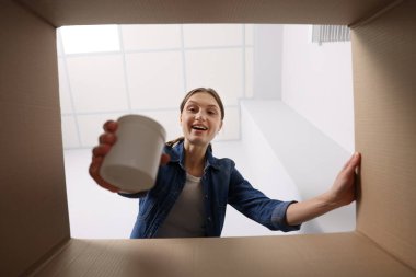 Karton kutudan kavanozu çıkaran kadın, içeriden bakan kadın.