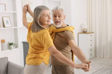 Güzel yaşlı çift evde dans ediyor.