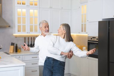 Mutlu son sınıf çifti mutfakta dans ediyor.