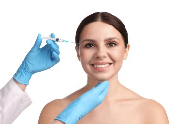 Estetik ameliyat. Doktor beyaz arka plandaki hastaya yüz enjeksiyonu yapıyor.