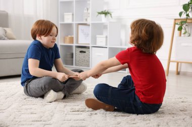 Evde tablet üzerinde kavga eden iki kardeş.